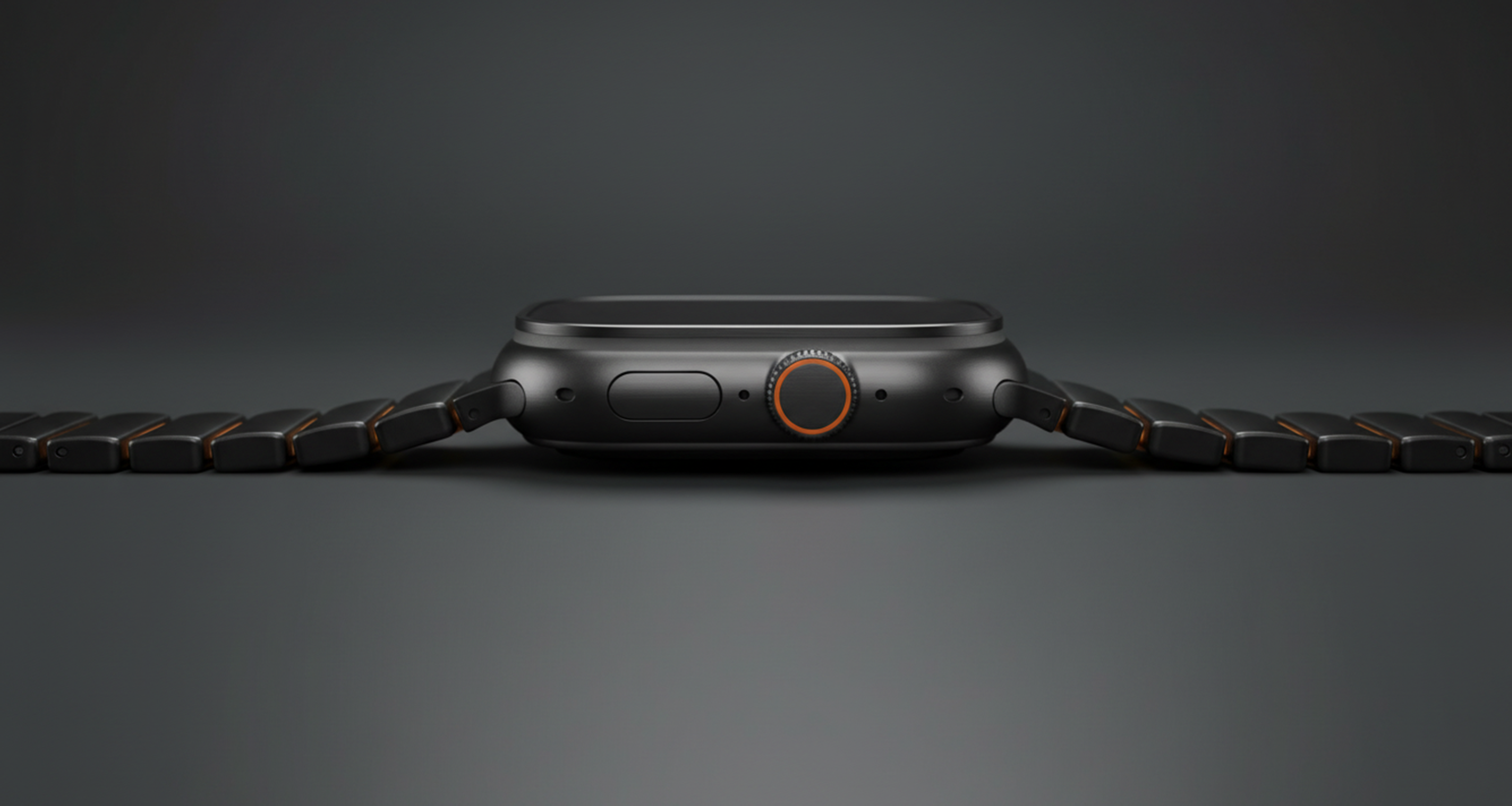 Komodoty's Apple Watch Band titanium with a black band and orange accent links on a dark gray background desktop