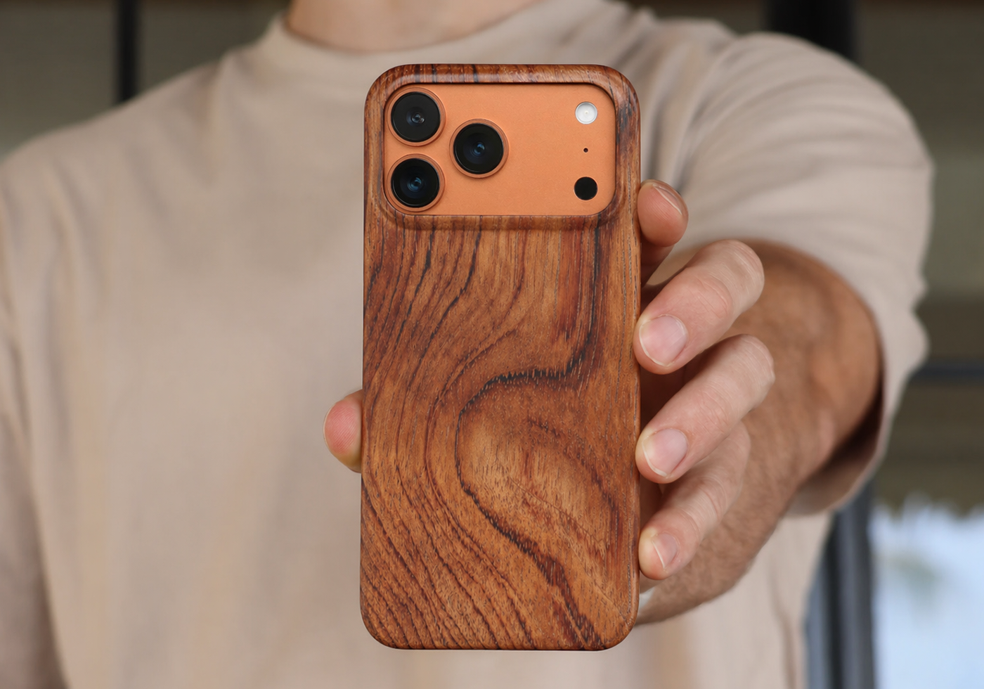 Hand holding an iPhone 17 Pro Max Rosewood Slim Wood Case with a wooden case