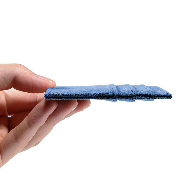 Glacier Blue Alcantara card wallet, side view held flat in one hand to show the slim profile, on a plain white background