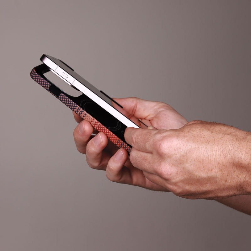 Oppo Find X9 Pro device being installed into a red patterned aramid fiber phone case against a gray background