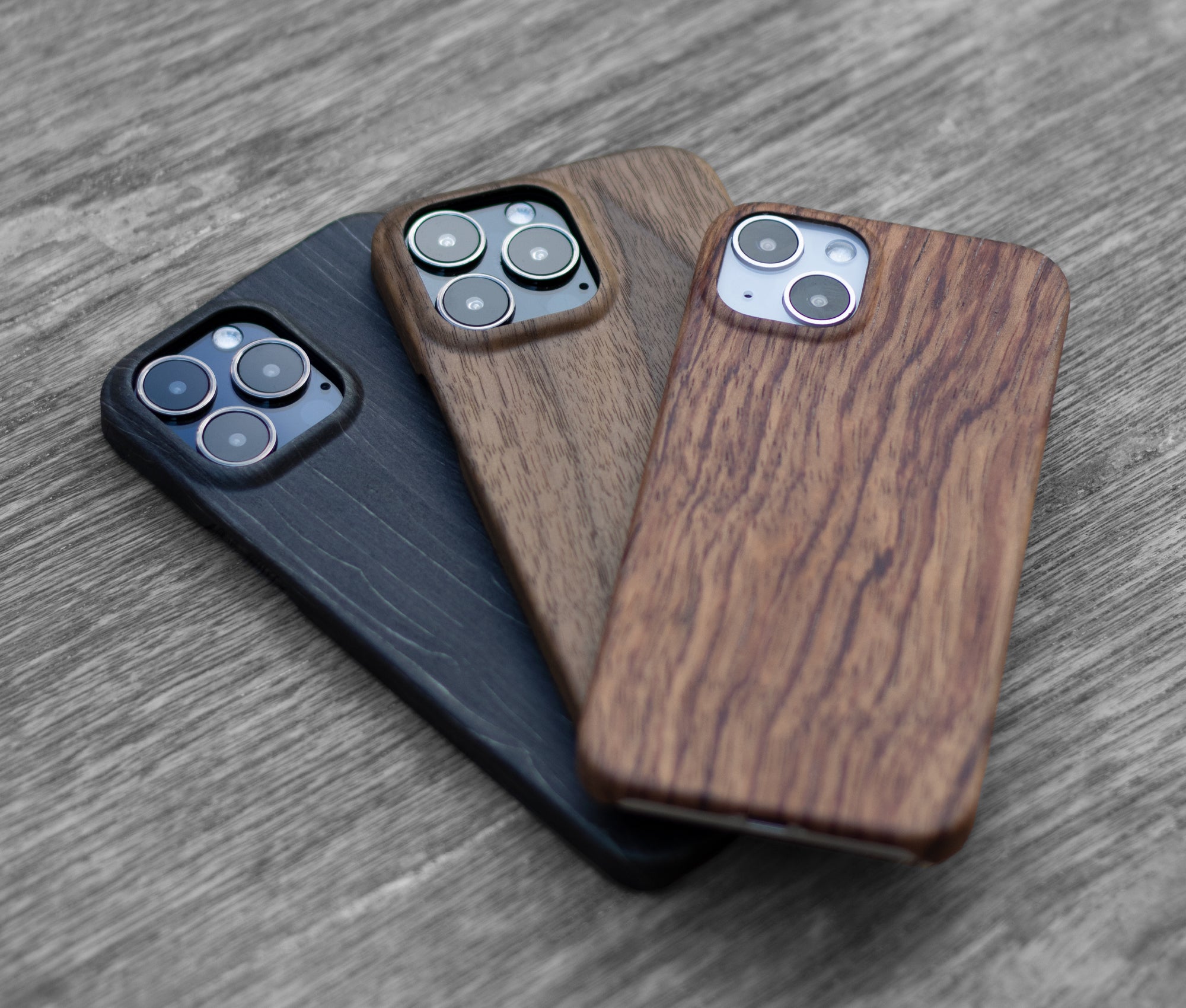 Komodoty Wood iPhone Cases stacked Charcoal Walnut Rosewood Wooden Table together